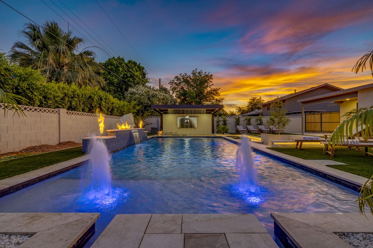 Finished pool with lit deck jets at twilight, Scottsdale backyard