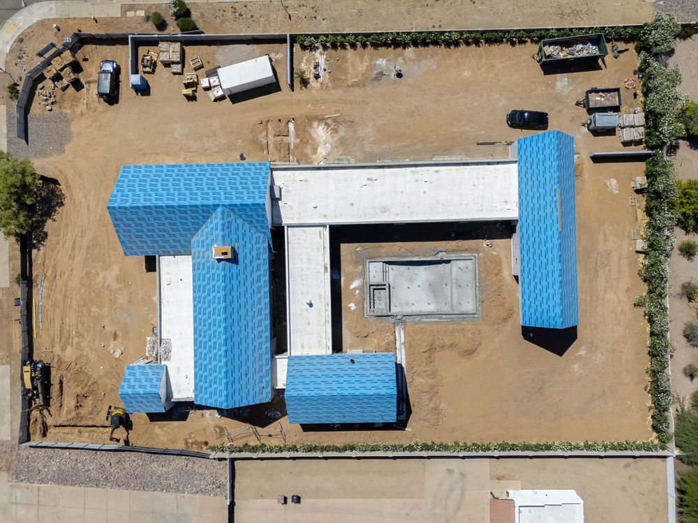 Top-down aerial of a roof with underlayment mid-install, Phoenix metro