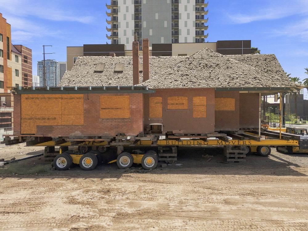 Historic building relocated on a commercial site next to a hotel